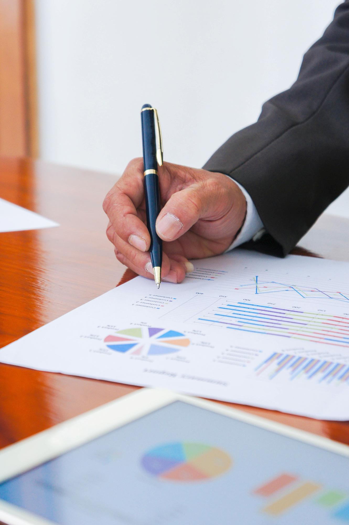 Advisor reviewing financial charts and data on a wooden desk
